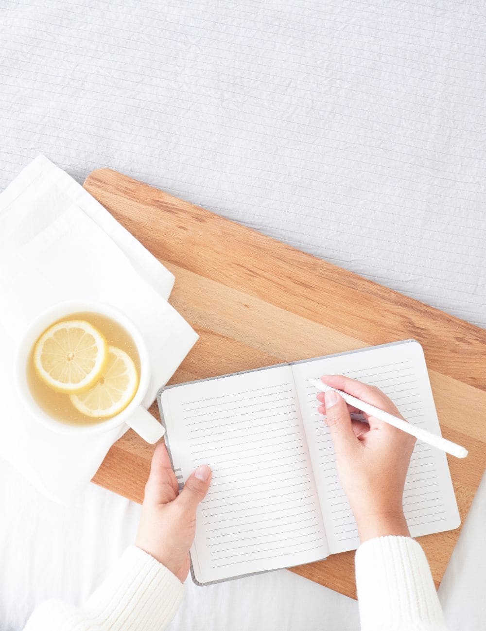 Lemon tea, hand holding pen and journal